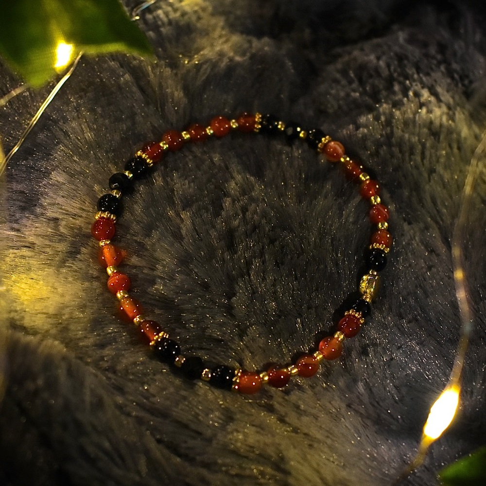 Orange, black, and gold beaded stretchy bracelet